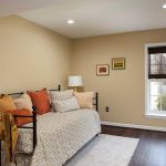 finished basement bedroom with wood floors and window