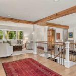 First floor walls and doors were removed to create an open floor plan. New supports created and banister to basement updated with wood and iron accents. rustic first floor of home